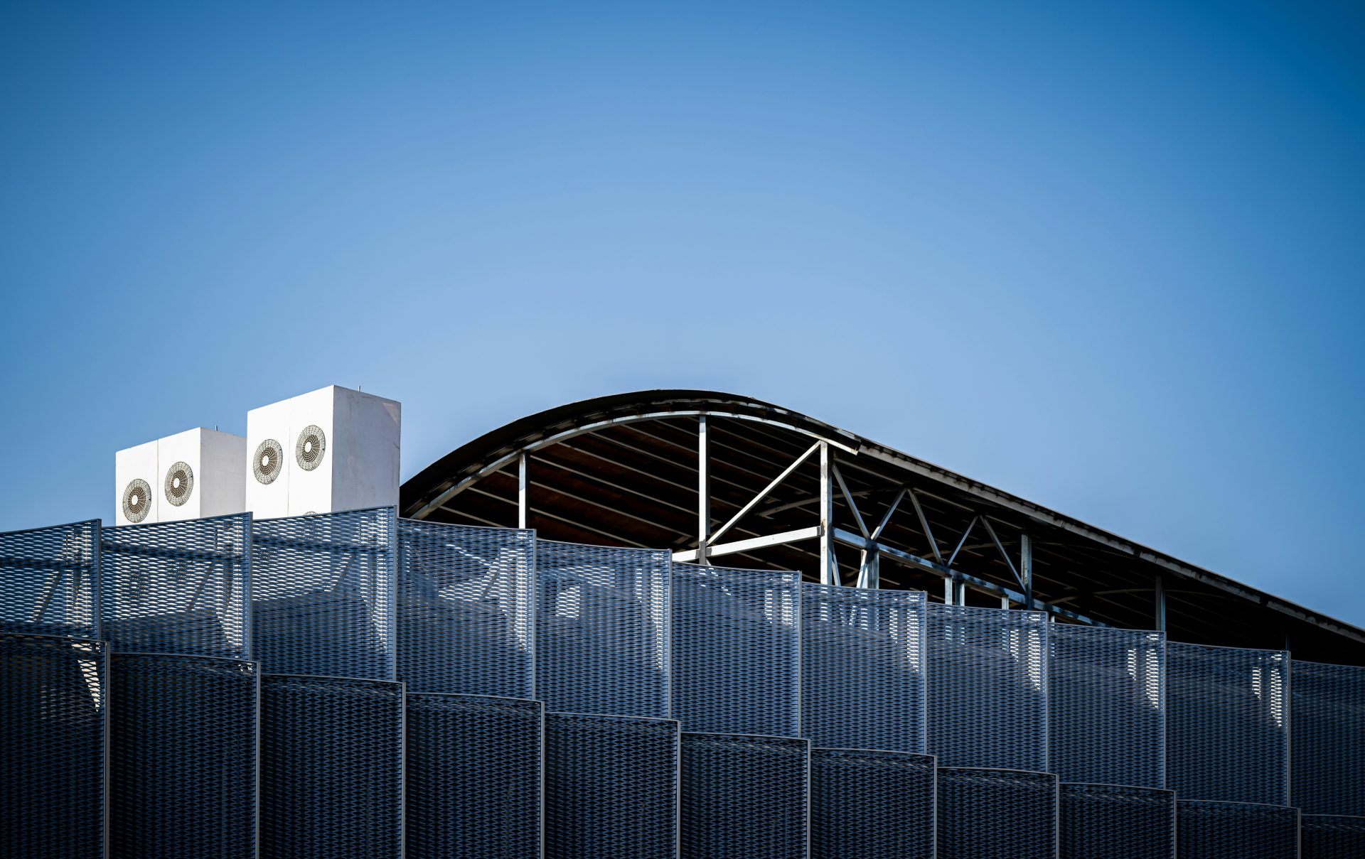 A large building with a roof and a sky background